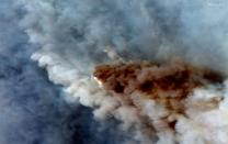 A natural color satellite image shows smoke from wildfires burning east of Obrost