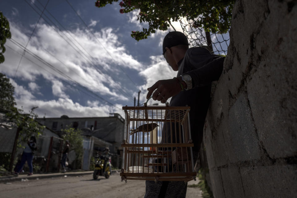 Odlanier Santiago Rodríguez, who was accused of participating in the recent protests against the government and released after 22 days in prison, waits by the door of his home in La Guinera neighborhood of Havana, Cuba, Wednesday, Jan. 19, 2022. Six months after surprising protests against the Cuban government, more than 50 protesters who have been charged with sedition are headed to trial and could face sentences of up to 30 years in prison. (AP Photo/Ramon Espinosa)