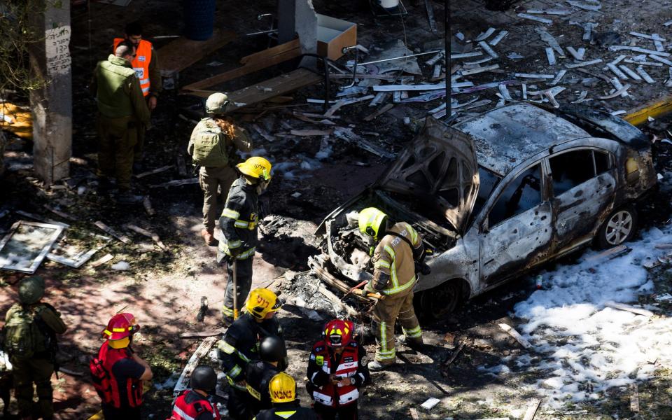  Firefighters put out a fire after a rocket fired from the Gaza Strip