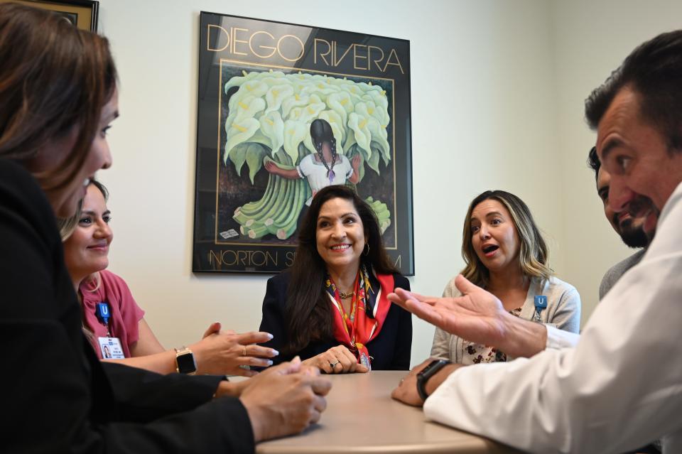 Cynthia Telles, director of the University of California, Los Angeles' Hispanic Neuropsychiatric Center of Excellence, (center) conducts an informal staff meeting in her office.