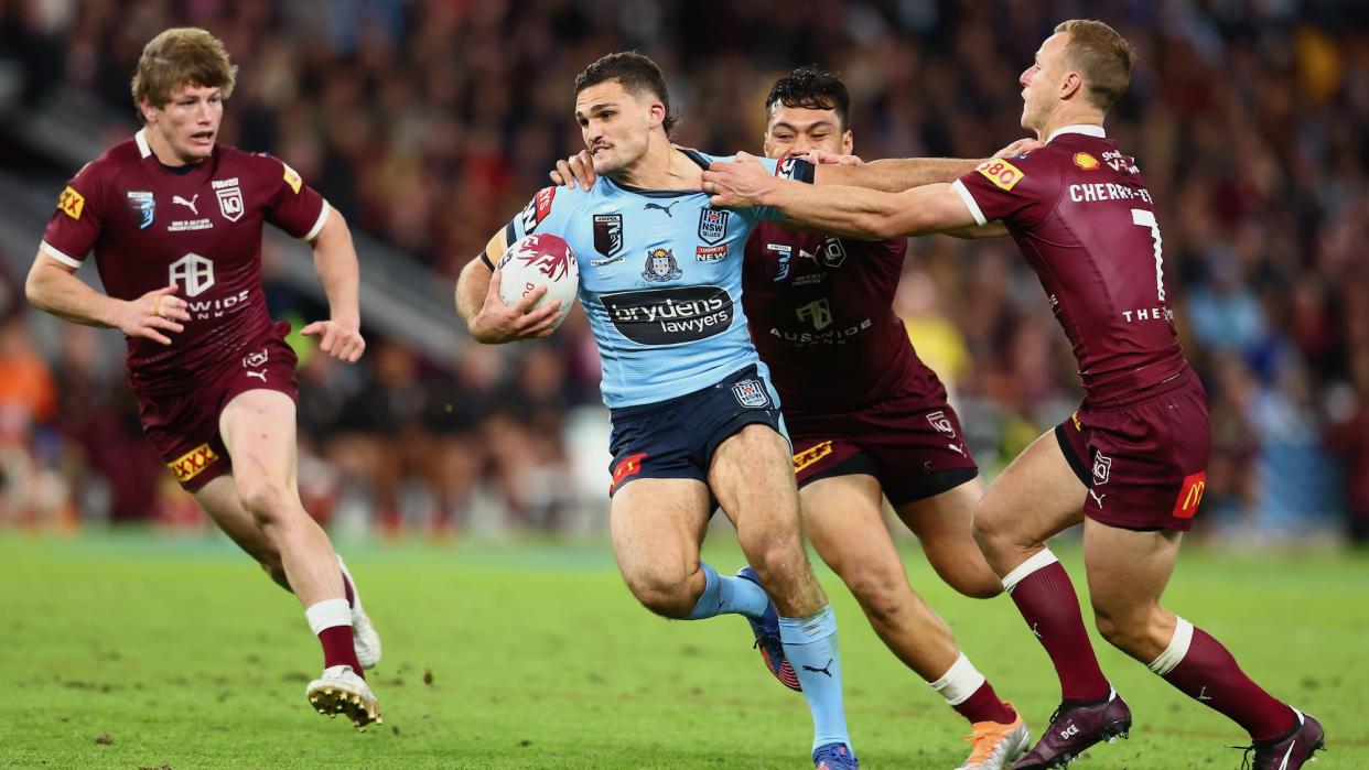  Nathan Cleary of the NSW Blues is tackled by the Queensland Maroons during game three of the State of Origin 2022. 