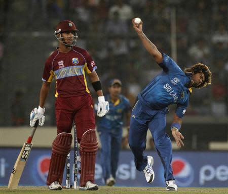 Sri Lanka's Lasith Malinga bowls as West Indies' Marlon Samuels (L) watches during their semi-final match in the ICC Twenty20 World Cup at the Sher-E-Bangla National Cricket Stadium in Dhaka April 3, 2014. REUTERS/Andrew Biraj