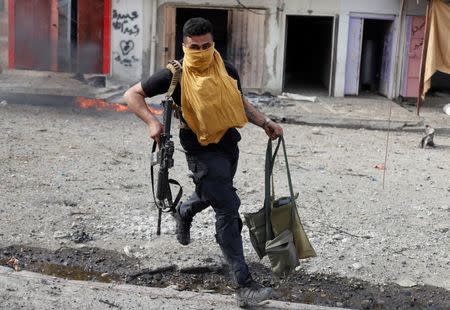 An Iraqi special forces soldier runs for cover during a battle with Islamic State militants in Mosul, Iraq March 1, 2017. REUTERS/Goran Tomasevic