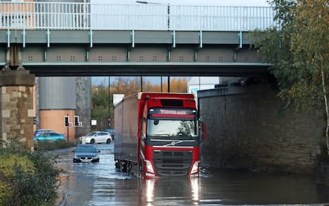 A lorry drives through floodwater near Meadowhall shopping centre in Sheffield - Credit: PA