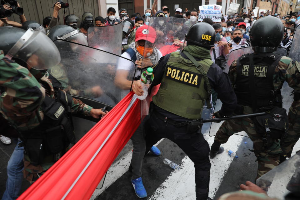 Police block supporters of former President Martin Vizcarra from reaching Congress as lawmakers swear-in Manuel Merino, head of Peru's legislature, as the new president in Lima, Peru, Tuesday, Nov. 10, 2020. Congress voted to oust Vizcarra over his handling of the new coronavirus pandemic and unproven allegations of corruption years ago. (AP Photo/Rodrigo Abd)