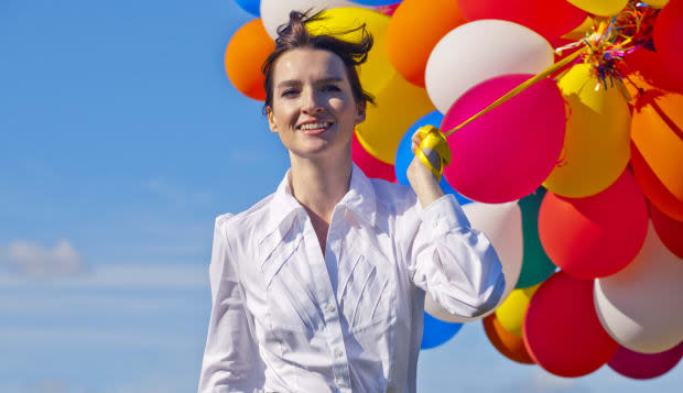 businesswoman holding bunch of balloons