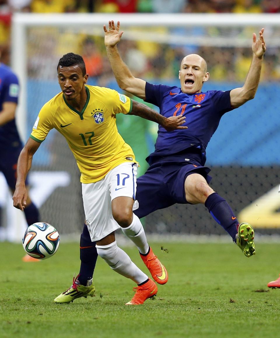 Brazil's Luiz Gustavo (L) and Arjen Robben of the Netherlands fight for the ball during their 2014 World Cup third-place playoff at the Brasilia national stadium in Brasilia July 12, 2014. REUTERS/Dominic Ebenbichler (BRAZIL - Tags: SOCCER SPORT WORLD CUP)