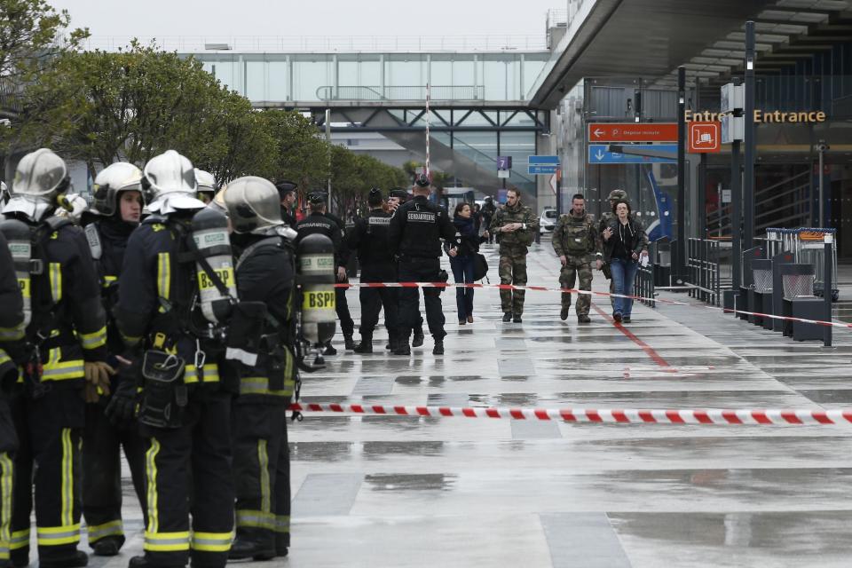 Police officers, rescue workers, left, and soldiers patrol outside the Orly airport , south of Paris, Saturday, March, 18, 2017. A man was shot dead after wrestling a soldier to the ground at Paris' Orly Airport and trying to take her rifle, officials said. No one else in the busy terminal was hurt, but thousands of travelers were evacuated and flights were diverted to the city's other airport. (AP Photo/Thibault Camus)