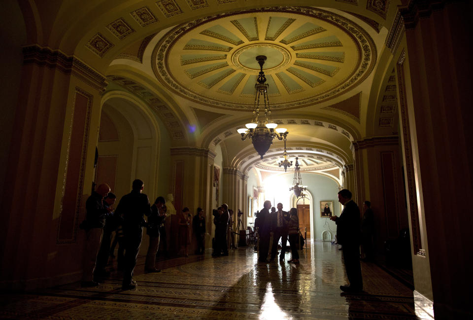 Reporters wait outside the Senate chamber on Capitol Hill on Monday, Oct. 14, 2013 in Washington. (AP Photo/ Evan Vucci)