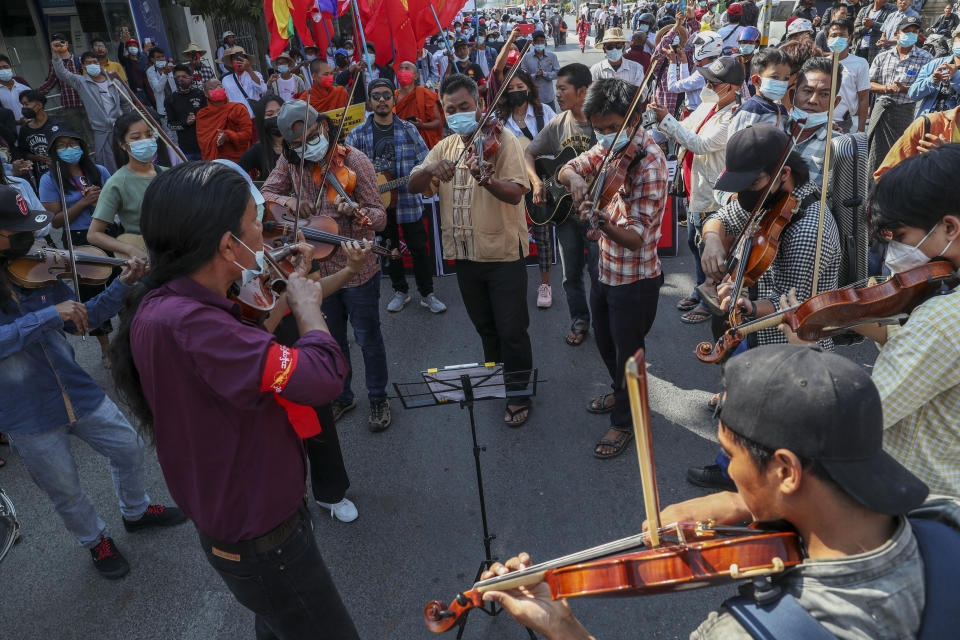 Anti-coup protesters play instruments and sing after riot policemen blocked their march in Mandalay, Myanmar, Wednesday, Feb. 24, 2021. Protesters against the military's seizure of power in Myanmar were back on the streets of cities and towns on Wednesday, days after a general strike shuttered shops and brought huge numbers out to demonstrate. (AP Photo)