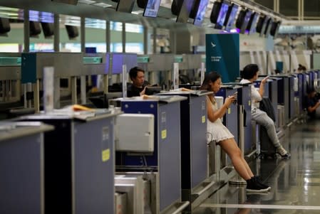 Passengers rest at the check-in counters in the departure hall after flights were cancelled during the anti-extradition bill protest at Hong Kong Airport