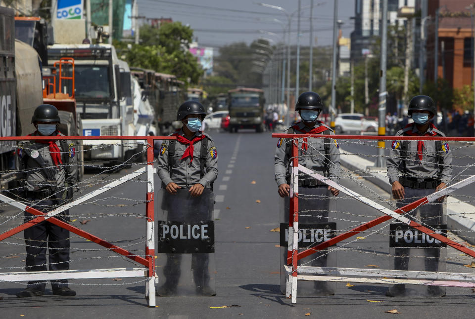 Police barricade a road to prevent anti-coup protesters from marching through in Mandalay, Myanmar, Wednesday, Feb. 24, 2021. Protesters against the military's seizure of power in Myanmar were back on the streets of cities and towns on Wednesday, days after a general strike shuttered shops and brought huge numbers out to demonstrate. (AP Photo)