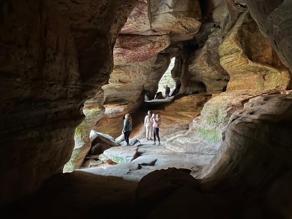 Visitors explore Rock House in Hocking Hills State Park. Hocking Hills is a popular destination for travelers.