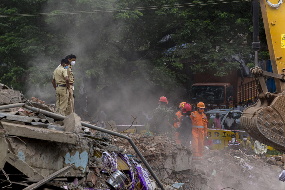 Indian rescue workers search for people in the rubble of a collapsed five-storey apartment building in Mahad. (Photo by Imtiyaz Shaikh/Anadolu Agency via Getty Images)