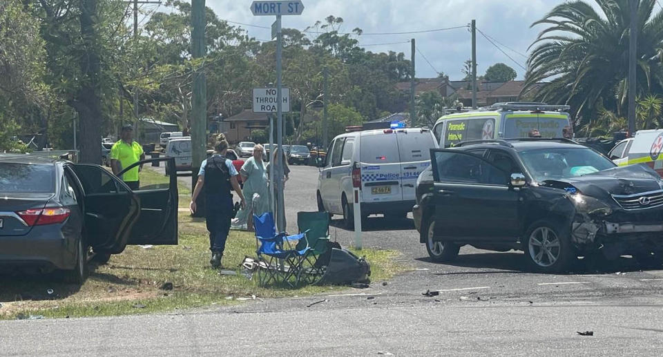 A photo of the crash scene, involving the Toyota sedan and Lexus SUV, as well as a police car and two ambulances.