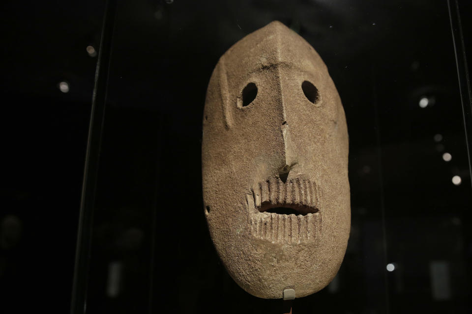 In this Monday, March 10, 2014 photo, a 9,000 year-old mask is on display at the Israel Museum in Jerusalem. The exhibition called "Face To Face" shows eleven stone masks, said to have been discovered in the Judean desert and hills near Jerusalem, which date back 9,000 years and offer a rare glimpse at some of civilization’s first communal rituals. (AP Photo/Tsafrir Abayov)