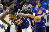 Phoenix Suns forward Kevin Durant (35) drives against Minnesota Timberwolves guard Anthony Edwards (1) during the first half of an NBA basketball game Wednesday, March 29, 2023, in Phoenix. (AP Photo/Ross D. Franklin)