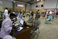 Heath workers register people before they can be vaccinated with the AstraZeneca COVID-19 vaccine, at a vaccination center in Karachi, Pakistan, Monday, May 10, 2021. (AP Photo/Fareed Khan)