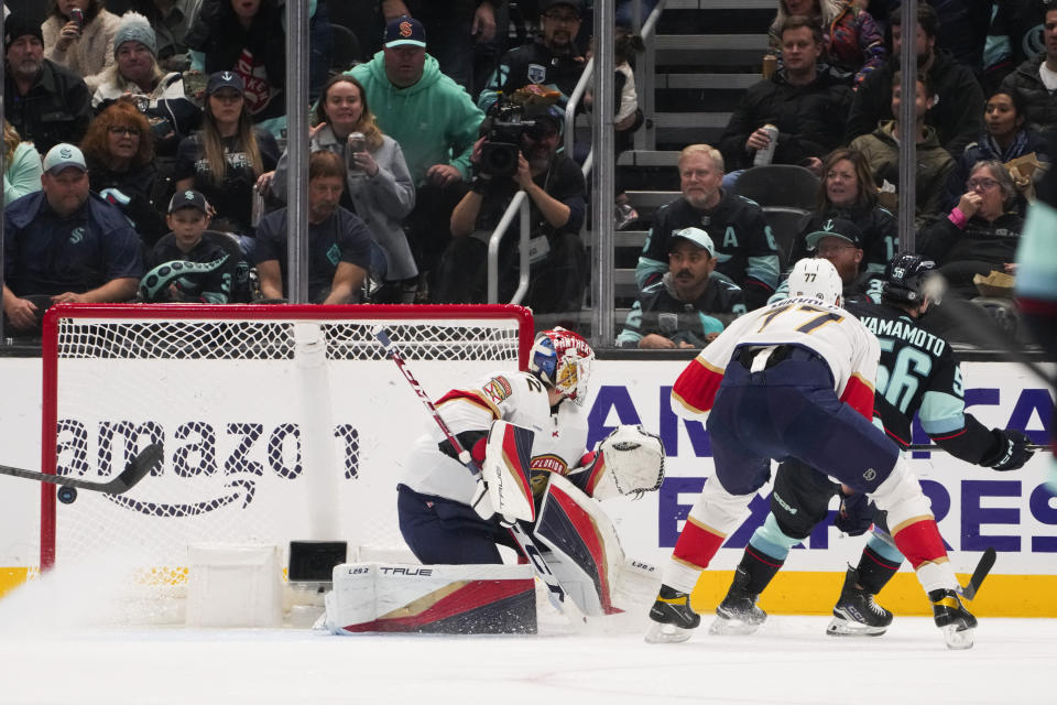 Seattle Kraken right wing Kailer Yamamoto (56) skates away from Florida Panthers defenseman Niko Mikkola (77) after scoring against goaltender Sergei Bobrovsky, left, during the second period of an NHL hockey game Tuesday, Dec. 12, 2023, in Seattle. (AP Photo/Lindsey Wasson)