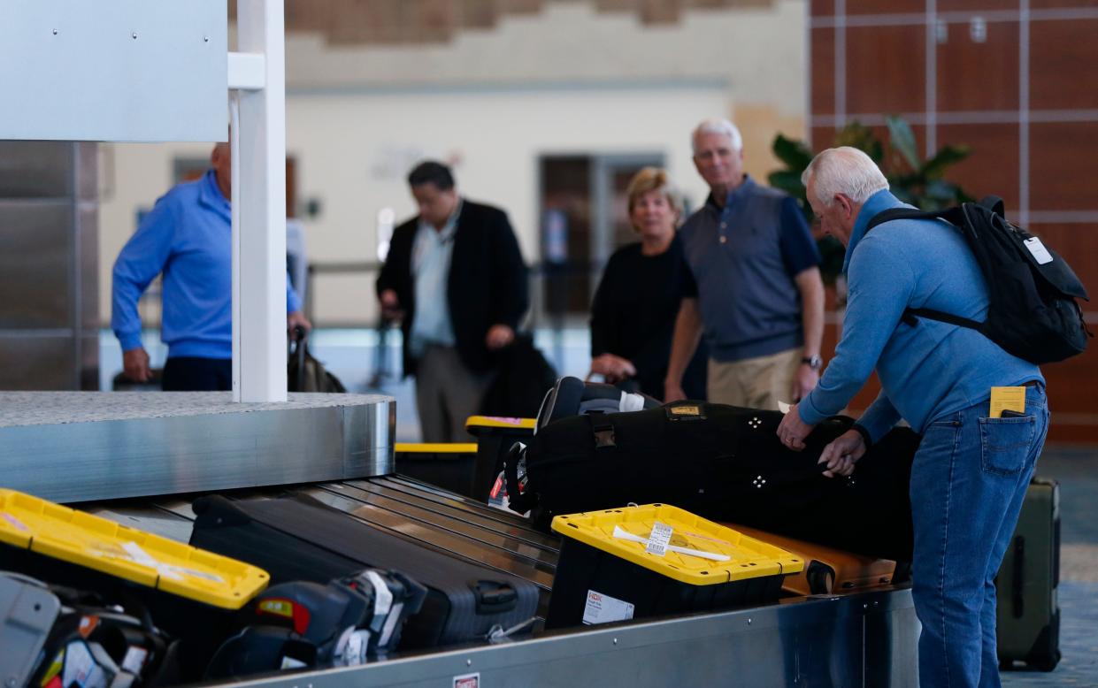 Travelers collect their luggage from baggage claim at the Springfield-Branson National Airport on Tuesday, April 19, 2022. Masks were made optional on public transit, including on airplanes and at airports, after a ruling by a federal judge in Florida voided the mask mandate.