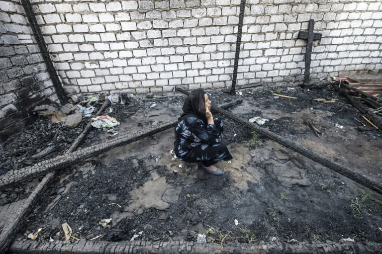 An Egyptian Coptic Christian woman on July 24, 2016 sits in the rubble of a makeshift chapel that was torched a few months ago during clashes in the Egyptian village of Ismailia