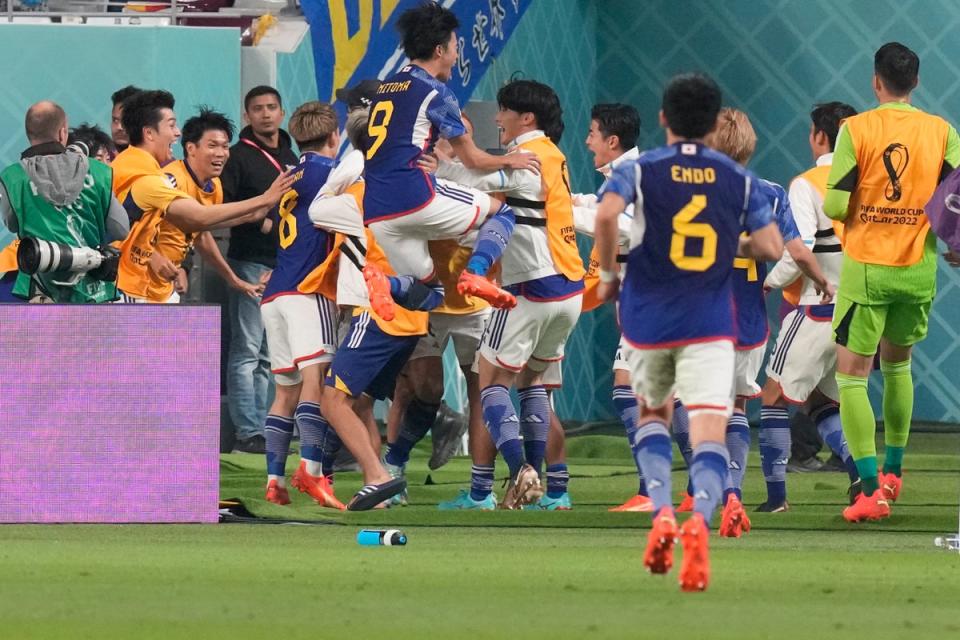 Japan’s players celebrate Takuma Asano’s winning goal (AP)