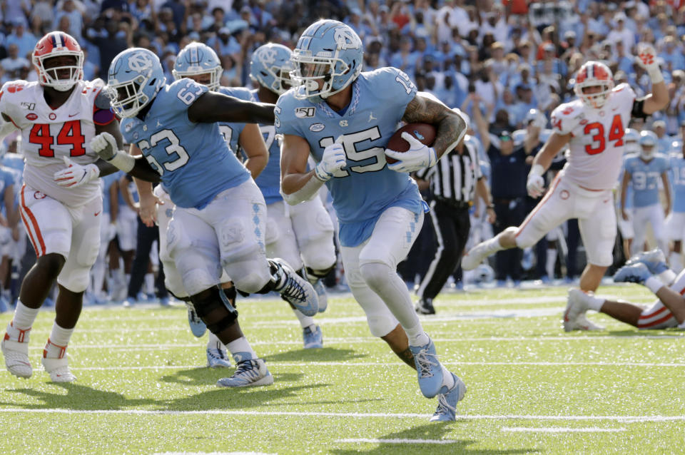 North Carolina's Beau Corrales (15) runs for a touchdown behind the block of Ed Montilus (63) while Clemson's Nyles Pinckney (44) looks on during the second quarter of an NCAA college football game in Chapel Hill, N.C., Saturday, Sept. 28, 2019. (AP Photo/Chris Seward)