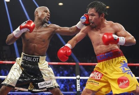 Floyd Mayweather, Jr. of the U.S. lands a left to the face of Manny Pacquiao of the Philippines (R) in the 11th round during their welterweight WBO, WBC and WBA (Super) title fight in Las Vegas, Nevada, May 2, 2015. REUTERS/Steve Marcus