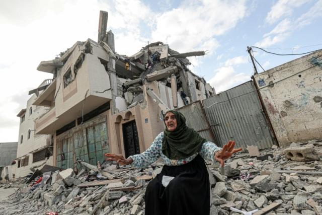 Una anciana entre los escombros frente a un edificio alcanzado por un ataque aéreo israelí en Jan Yunis, en el sur de la Franja de Gaza, el 13 de mayo de 2023
