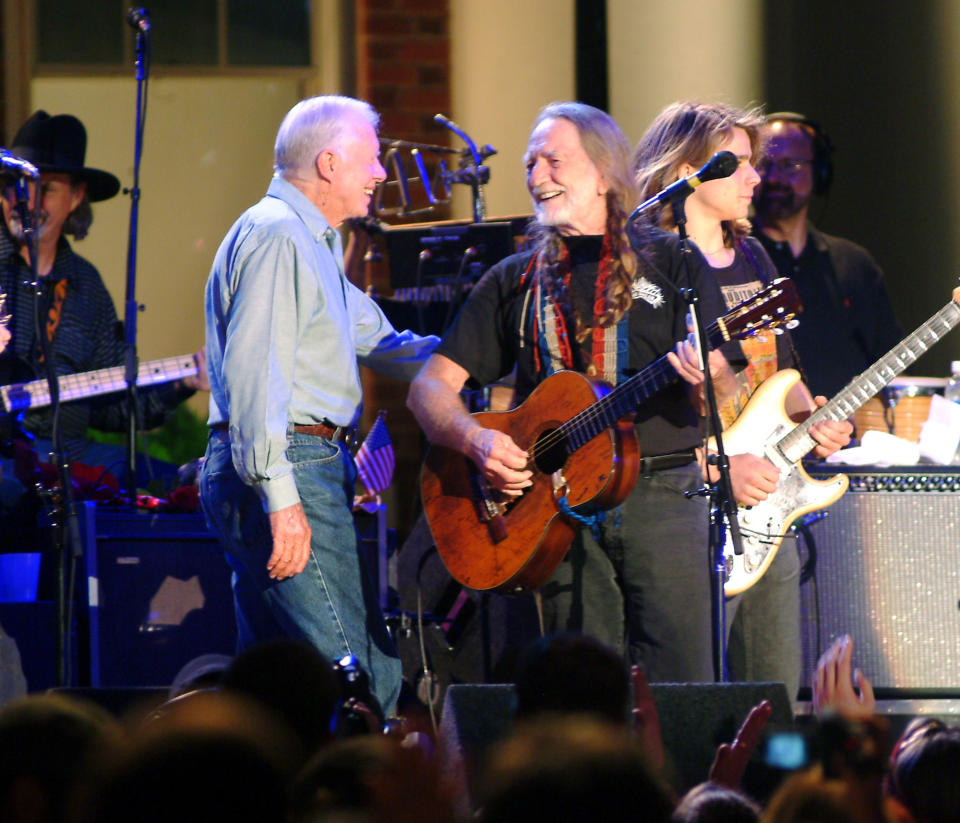 Former President Jimmy Carter, left, joins country music legend Willie Nelson on the stage at Plains, Ga., on Thursday, Sept. 9, 2004. (Photo: AP/Todd Stone)
