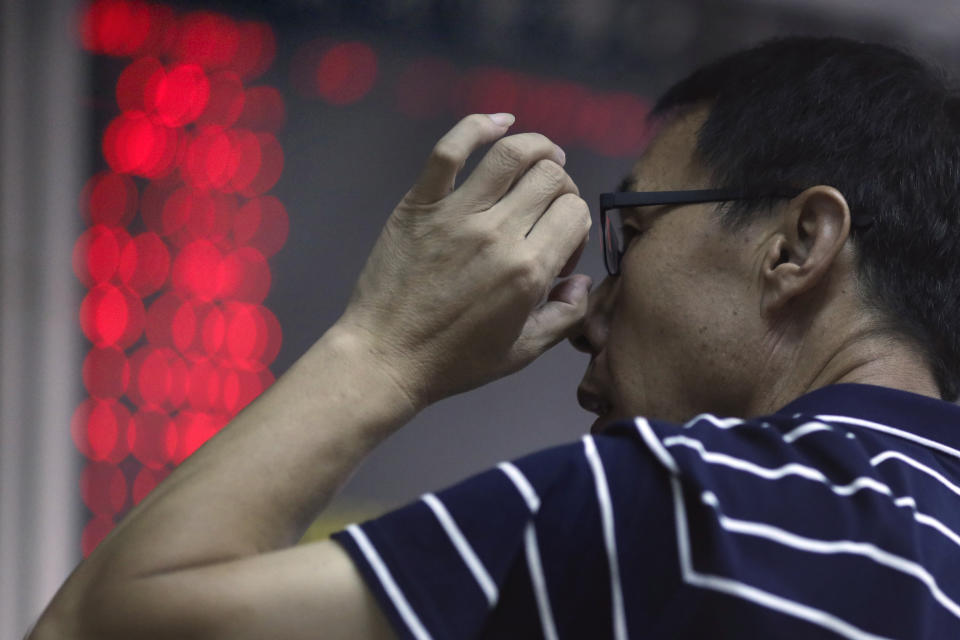 In this Sept. 25, 2019, photo, a Chinese man adjusts his glasses as he monitors stock prices at a brokerage in Beijing. Asian stock markets followed Wall Street higher Thursday, Sept. 26, 2019, after U.S. President Donald Trump suggested a costly tariff war with China could be resolved soon. (AP Photo/Ng Han Guan)