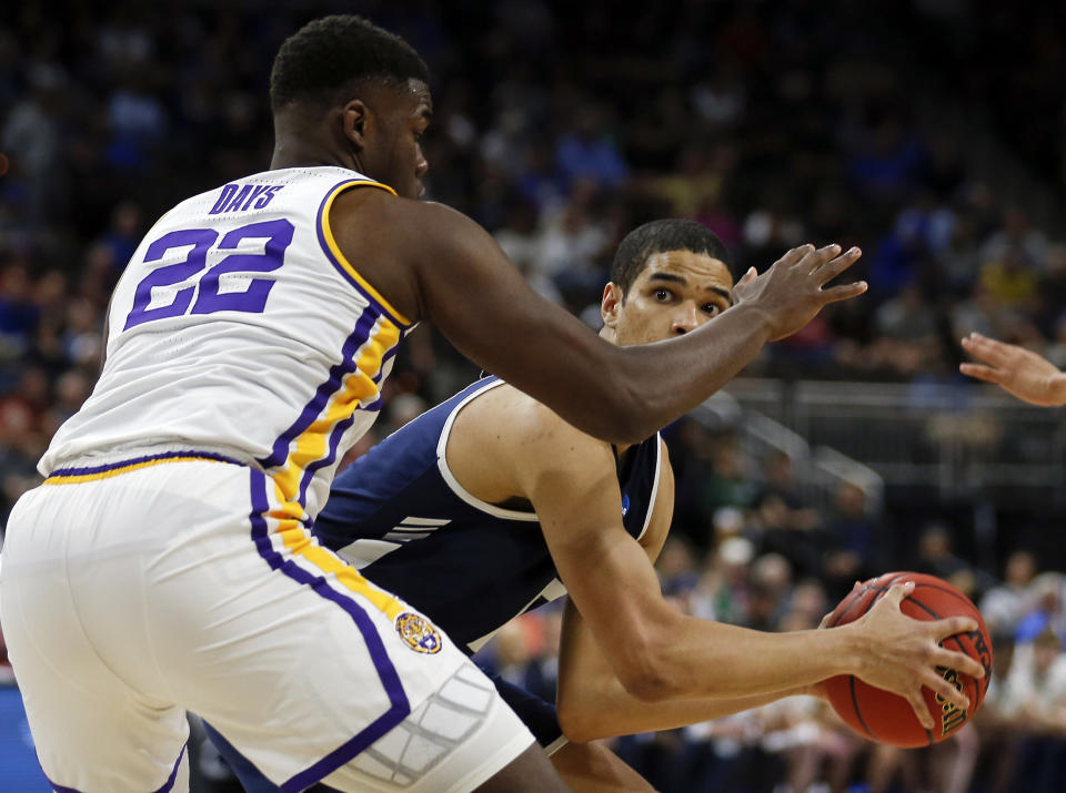 Yale 's Paul Atkinson, right, looks for a shot over LSU's Darius Days (22) during the first half of a first round men's college basketball game in the NCAA Tournament in Jacksonville, Fla., Thursday, March 21, 2019. (AP Photo/Stephen B. Morton)