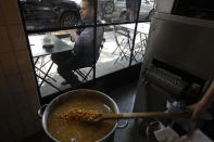 A cook displays corn kernels left to soak overnight in water and "kal," for the traditional Mexican "nixtamalization" process for the making of tortillas at El Pujol Mill in the Condesa neighborhood of Mexico City, Tuesday, April 9, 2019. The shop is part of a new tortilla movement launched by a handful of chefs, restaurants and organizations to restore and popularize authentic tortillas, made of only corn, water and lime or calcium carbonate. (AP Photo/Rebecca Blackwell)