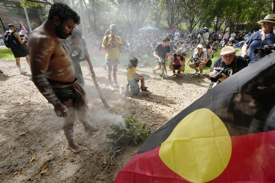 Neenan Simpson tends a smoldering fire that will be used for a smoking ceremony at an Indigenous Australians protest during Australia Day in Sydney, Friday, Jan. 26, 2024. Thousands of Australians protest on the anniversary of British colonization of their country amid fierce debate over whether the increasingly polarizing national holiday dubbed "Australia Day" should be moved to another date. (AP Photo/Rick Rycroft)