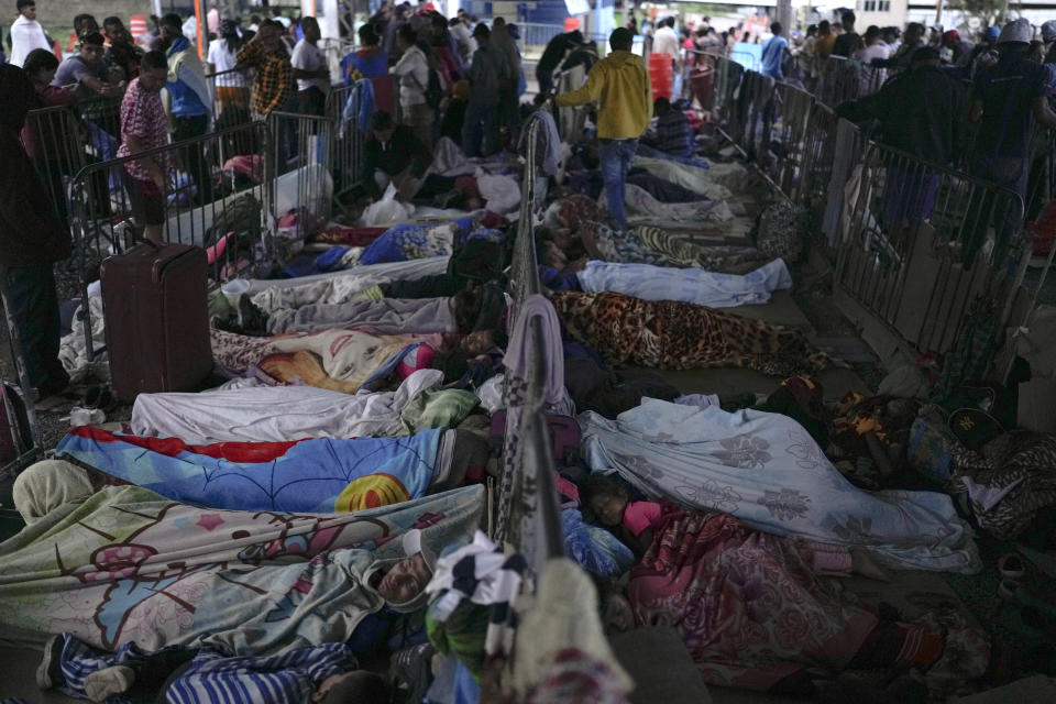 Venezuelan migrants wait to enter a temporary migrant shelter, run by an NGO, and for visas to legally enter Brazil, in Pacaraima, Brazil, on the border with Venezuela, early Thursday, April 27, 2023. (AP Photo/Matias Delacroix)