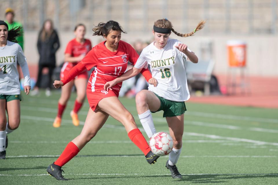 Pueblo County’s Pierson Weimer, right, battles for possession with Pueblo Centennial’s Maya Mondragon at Dutch Clark Stadium on March 30, 2022.