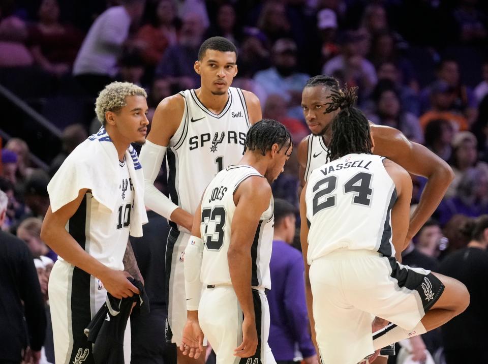 San Antonio Spurs center Victor Wembanyama (1) and his teammates huddle during the second quarter against the Phoenix Suns at Footprint Center in Phoenix on Oct. 31, 2023.