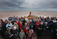 Members of the Churches Together in Sidmouth take part in their annual Good Friday Walk of Witness procession on the seafront in Sidmouth, England.