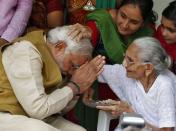 Hindu nationalist Narendra Modi (L), the prime ministerial candidate for India's main opposition Bharatiya Janata Party (BJP), seeks blessings from his mother Heeraben at her residence in Gandhinagar in the western Indian state of Gujarat May 16, 2014. REUTERS/Amit Dave