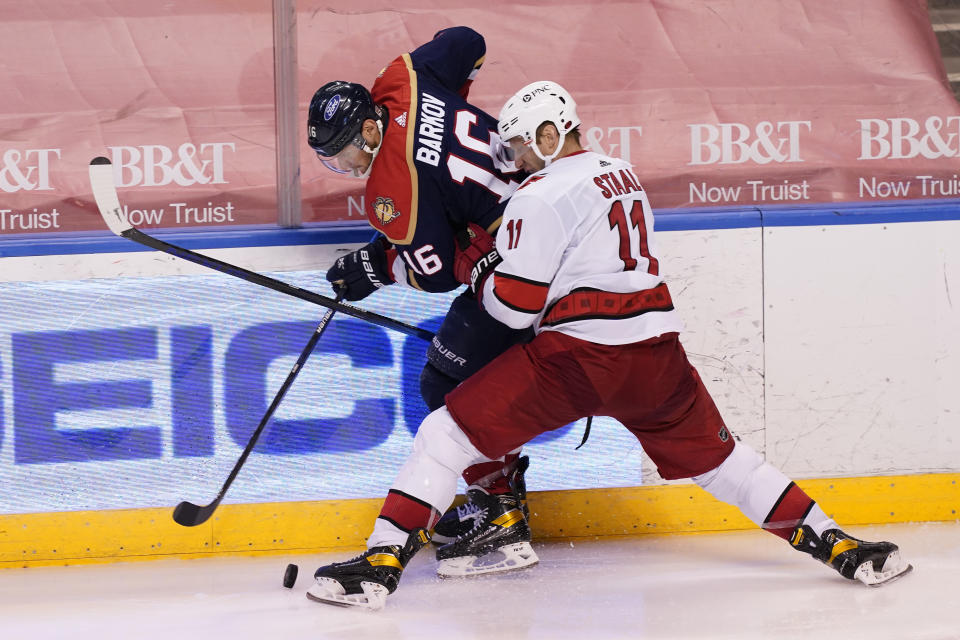 Carolina Hurricanes center Jordan Staal (11) and Florida Panthers center Aleksander Barkov (16) fight for the puck during the third period at an NHL hockey game, Saturday, Feb. 27, 2021, in Sunrise, Fla. (AP Photo/Marta Lavandier)