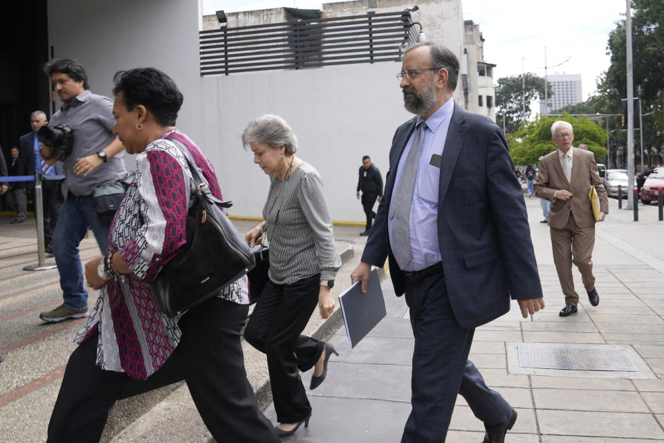 Jesus Maria Casal, president of the National Primary Commission, front right, arrives to the Attorney General's office where he was summoned about the opposition's recent primary elections in Caracas, Venezuela, Monday, Oct. 30, 2023. Prosecutors have opened a criminal investigation into primary organizers on charges including identity fraud and usurping authority and the government has maintained a ban on the primary winner from running for office. (AP Photo/Ariana Cubillos)