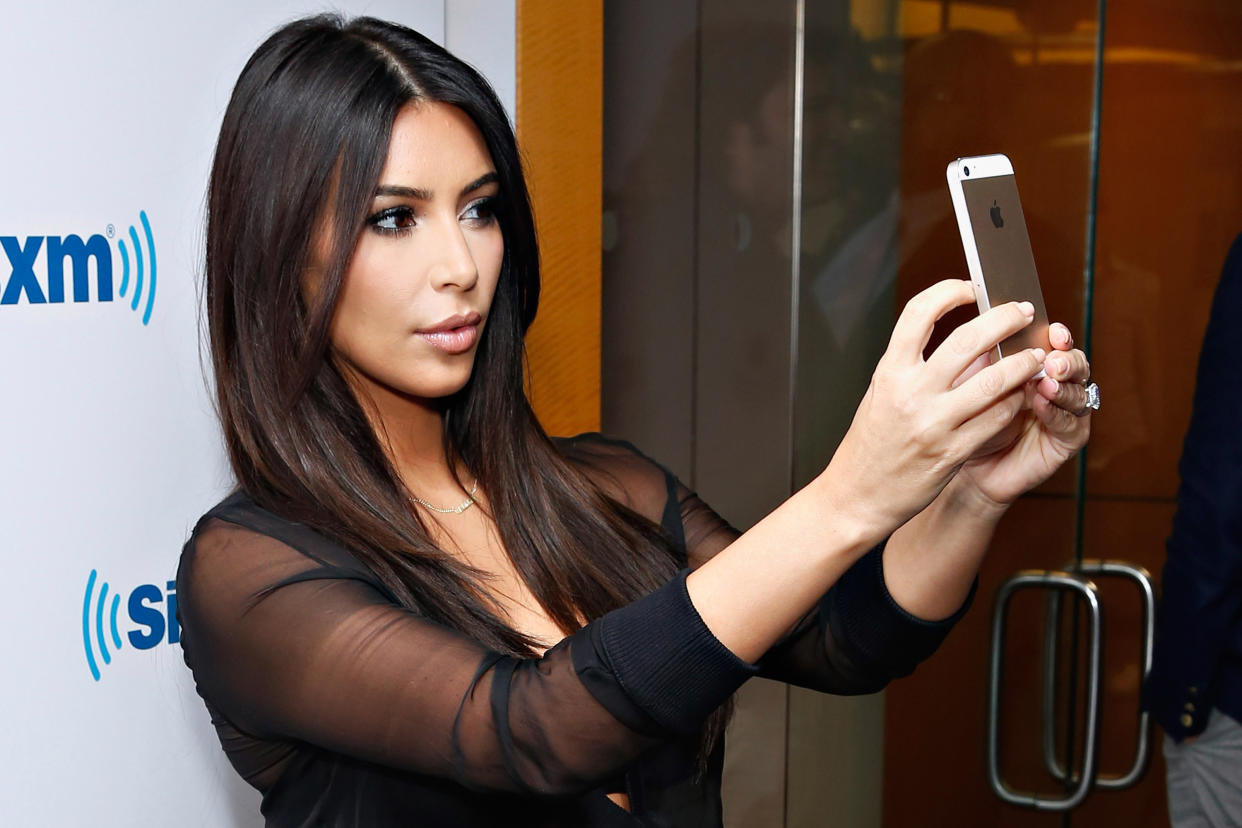 Kim Kardashian pauses to take a selfie. (Photo: Getty Images)