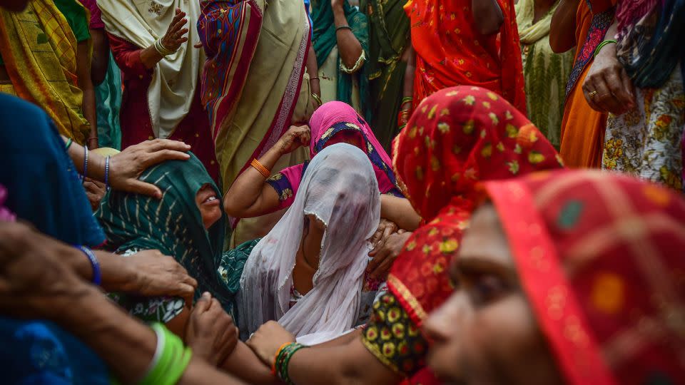 Relatives mourn outside of the home of three victims of the same family who died in the crush. - Ritesh Shukla/Getty Images