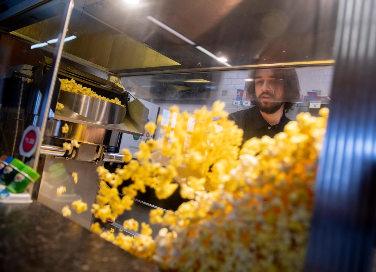 John Bearss makes a batch of popcorn at the Ravenna 7 Movies concession stand.