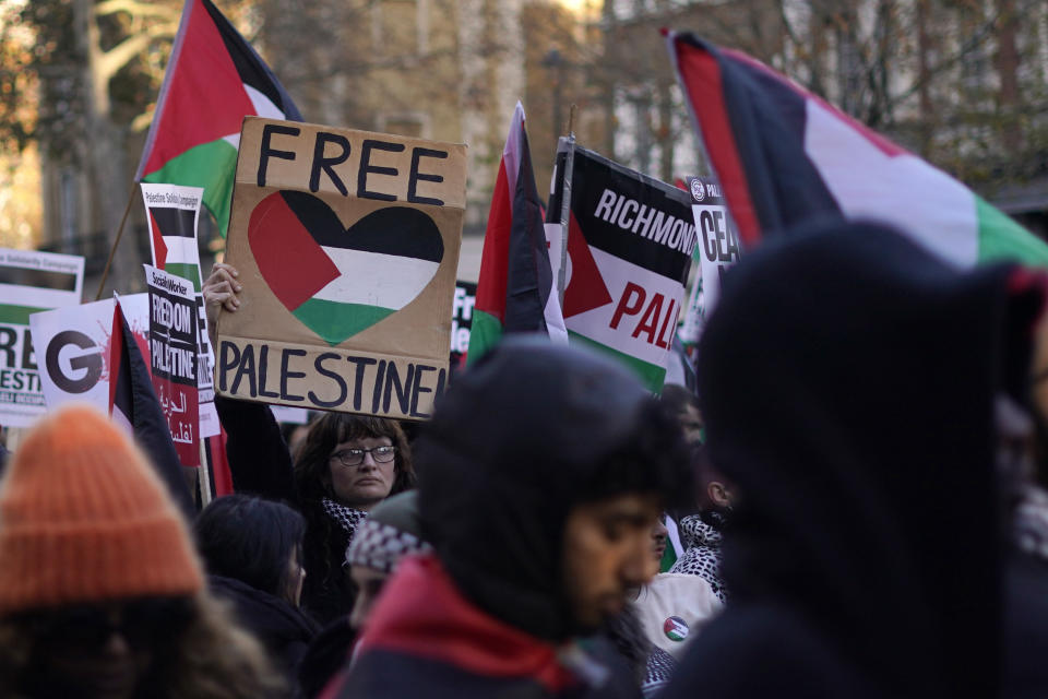 Protester hold flags and placards as they take part in a pro-Palestinian demonstration as they wend their way along Whitehall in London, Saturday, Nov. 25, 2023. (AP Photo/Alberto Pezzali)