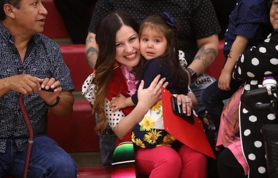 Graduate María Ríos Andrade holds her 2-year-old daughter Daliany during the 21st Latino Graduation Celebration at the college gym on May 6, 2023.