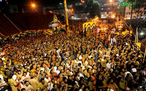 Hindu devotees pray at the Sabarimala temple during the Maravilakku festival in Pathanamthitta District, Kerala  - Credit: AFP