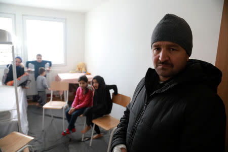 Afghan refugee Najibullah, 30, poses for a picture with his children at the camp for refugees and migrants in the Belgrade suburb of Krnjaca, Serbia, January 16, 2018. Picture taken January 16, 2018 REUTERS/Djordje Kojadinovic