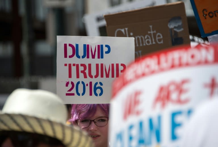 A young woman holds a sign against Republican presidential candidate Donald Trump in Philadelphia on July 24, 2016