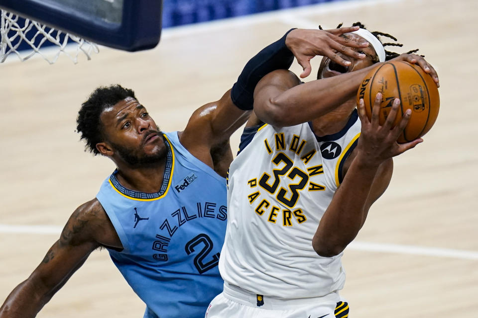 Indiana Pacers center Myles Turner (33) is fouled as he shoots by Memphis Grizzlies forward Xavier Tillman (2) during the second half of an NBA basketball game in Indianapolis, Tuesday, Feb. 2, 2021. (AP Photo/Michael Conroy)